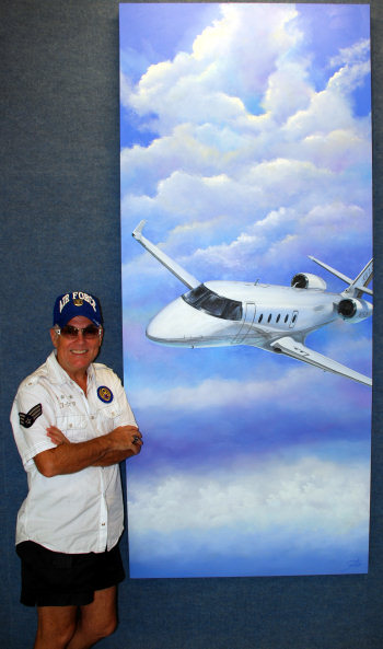 Sambataro standing next to an aviation art mural at FlightSafety International, Dallas